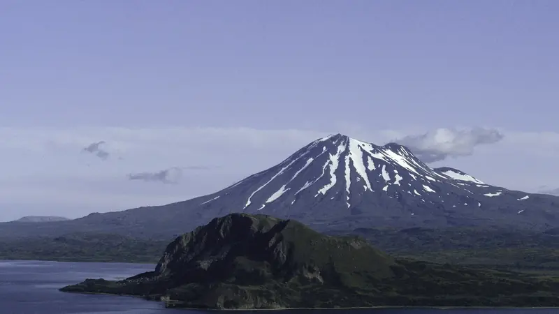 Illustrative photo: the snowy cone of Mount Peulik rising behind Becharof Lake