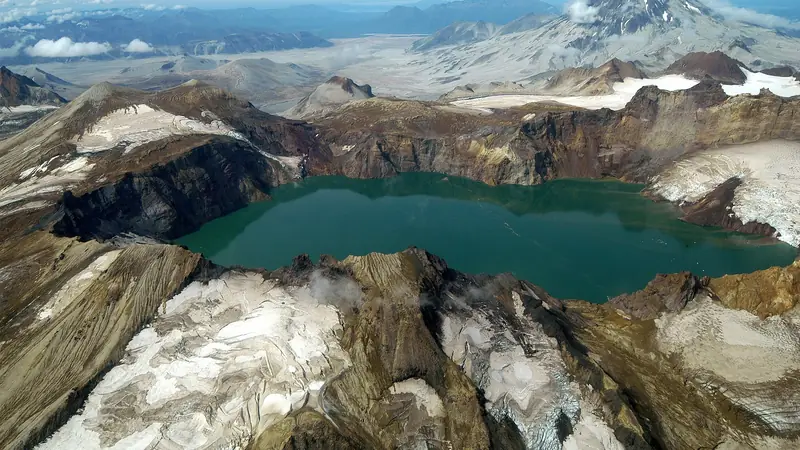 Illustrative photo: a crater lake among snowy volcanic peaks in Katmai