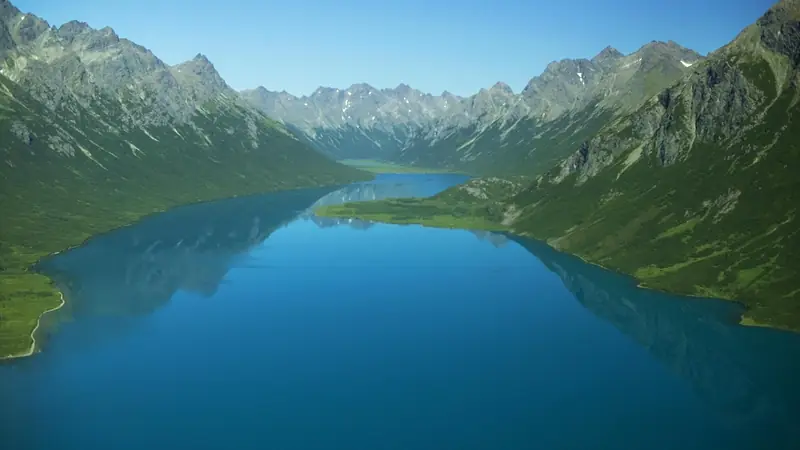 Illustrative photo: a long blue lake between steep green mountains