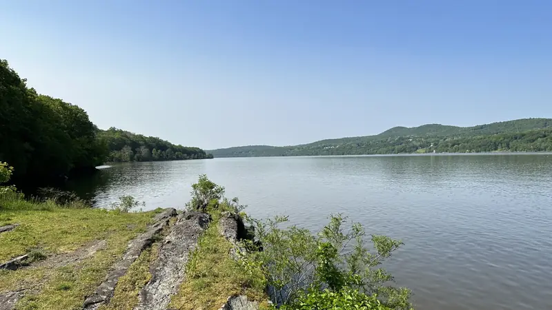 Illustrative photo: the Hudson River looking south from a rocky point, with green hills on the far shore