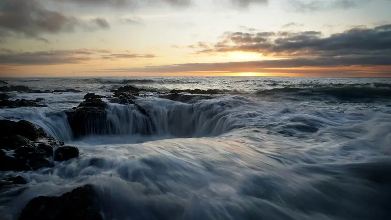 Illustrative photo: Surf draining over dark basalt at Cape Perpetua at sunset
